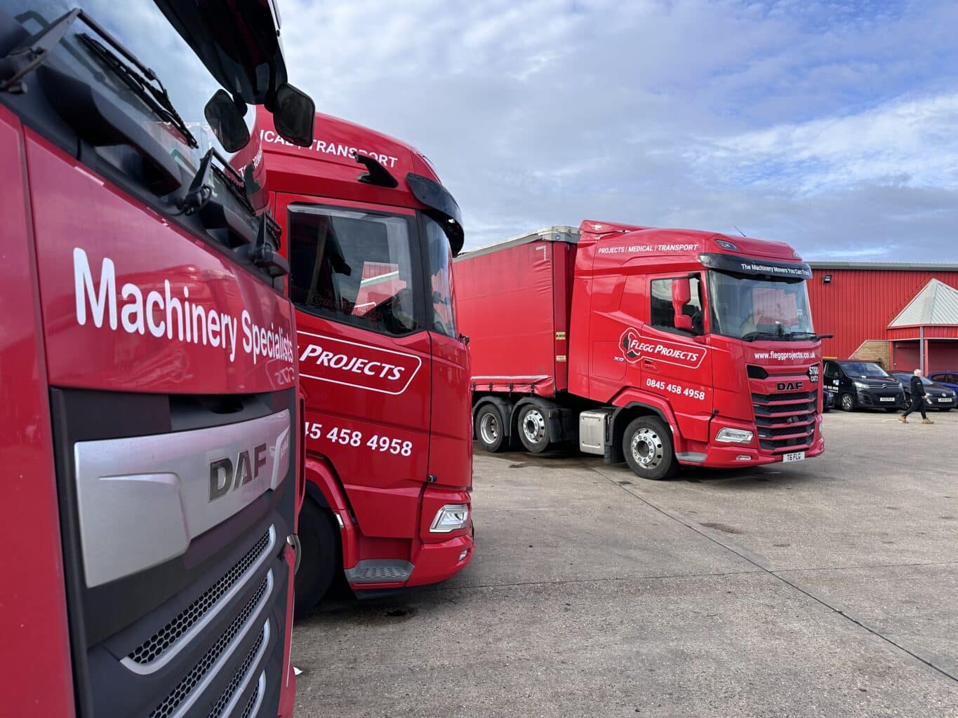 three red flegg trucks parked next to one another