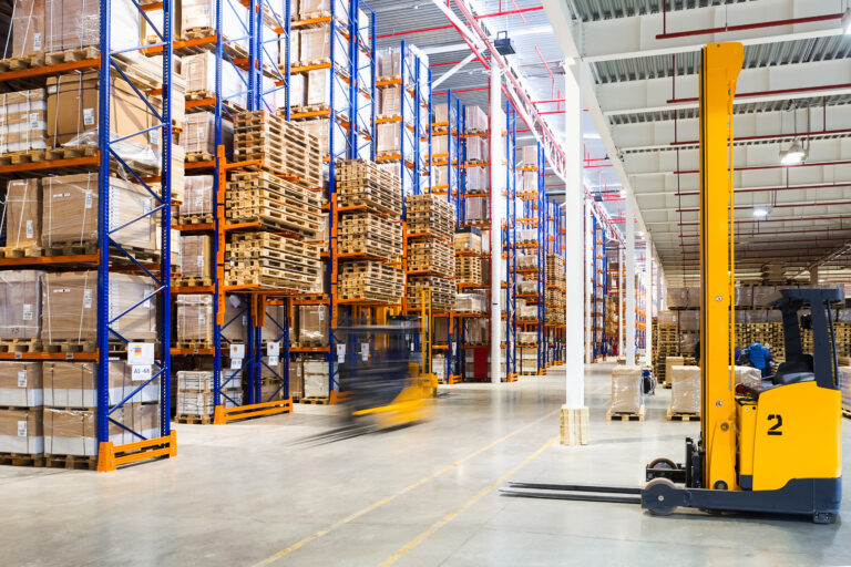 Warehouse aisles with pallet racking and forklift trucks.