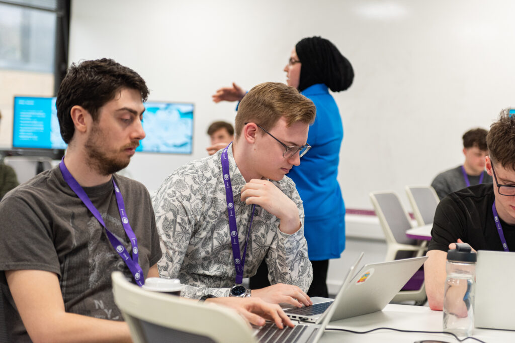 People working on laptops during a classroom session.