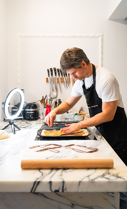 Chef preparing food on a marble kitchen island in a bright contemporary kitchen