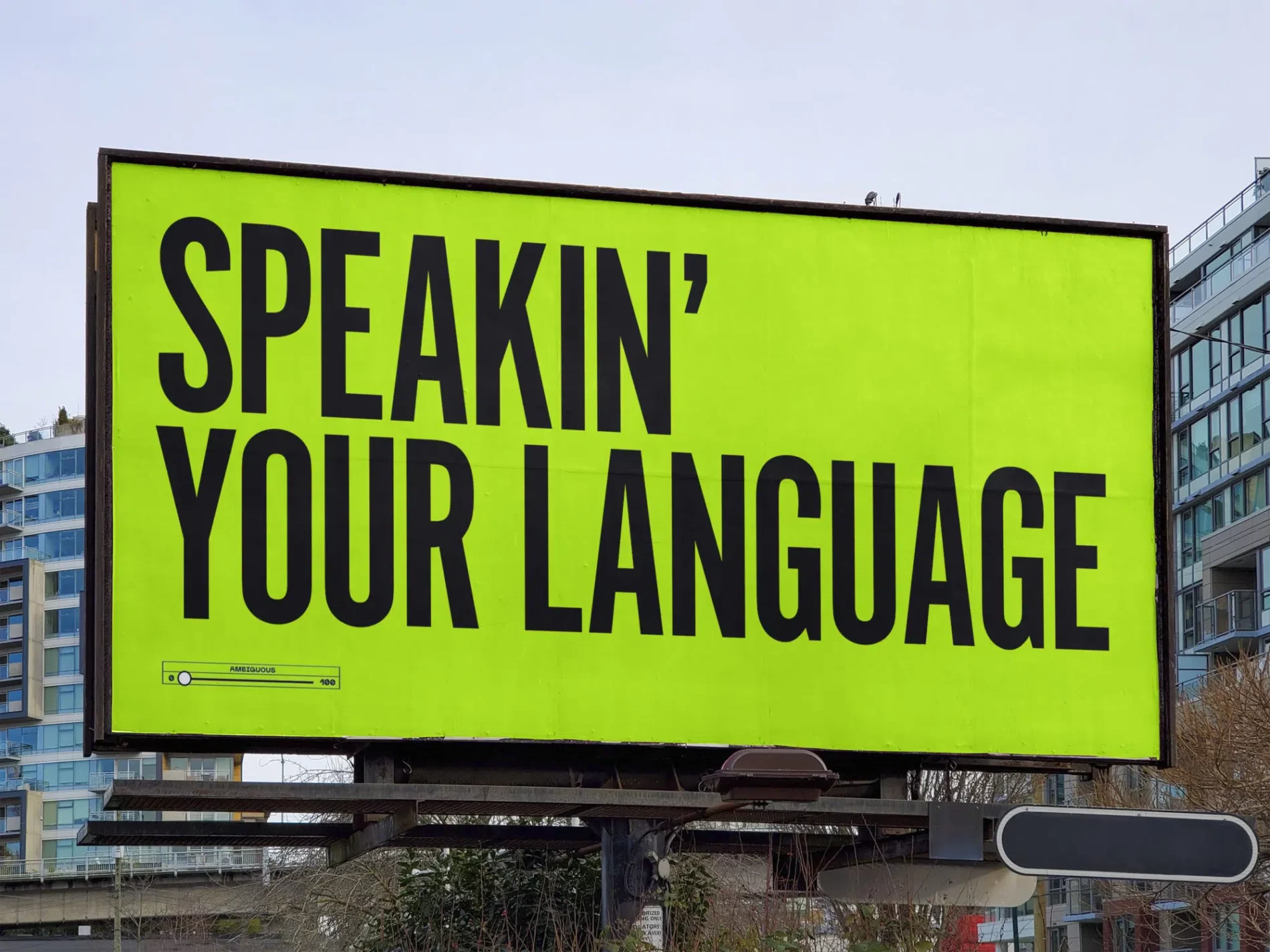 A bright green billboard with bold, black text that reads, "Speakin' Your Language," representing a clear and direct brand tone of voice.