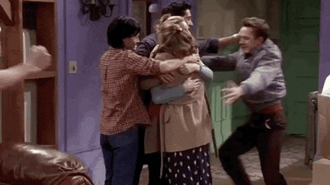 An excited group hug with the cast of the TV show Friends, showing celebration and happiness.