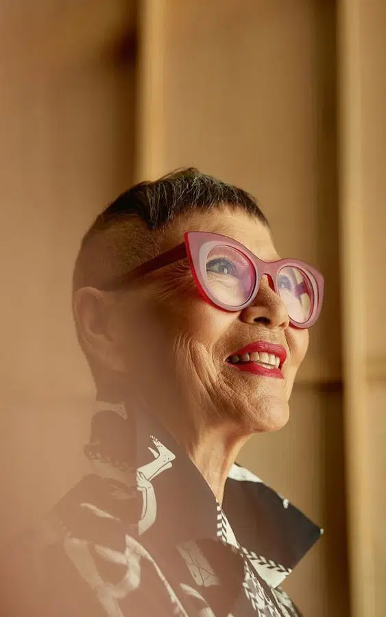 A portrait of a creative, older individual with stylish glasses, reflecting the people-first focus of the DramaHE brand identity.