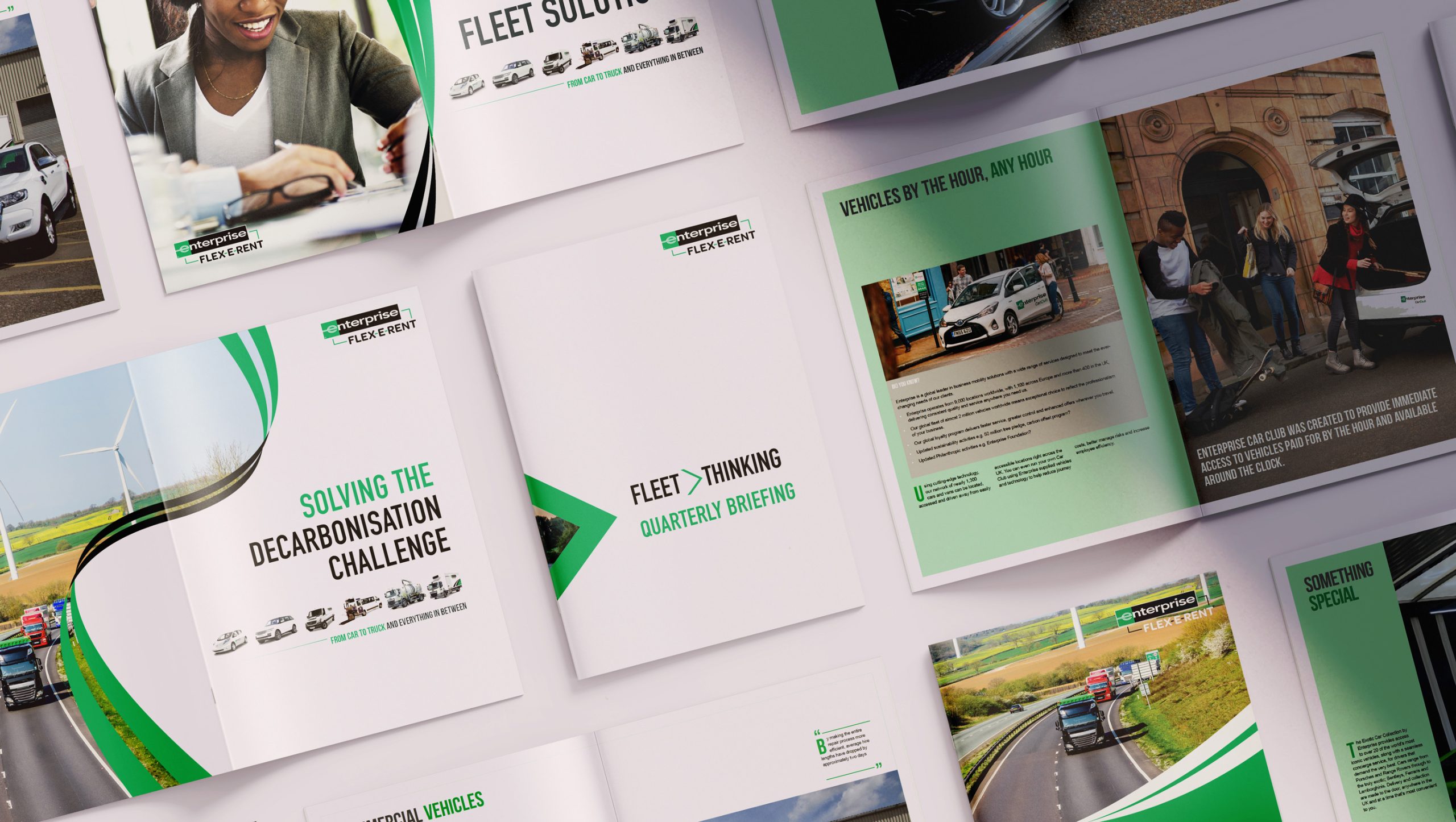 Enterprise marketing brochures and spreads laid out on a surface