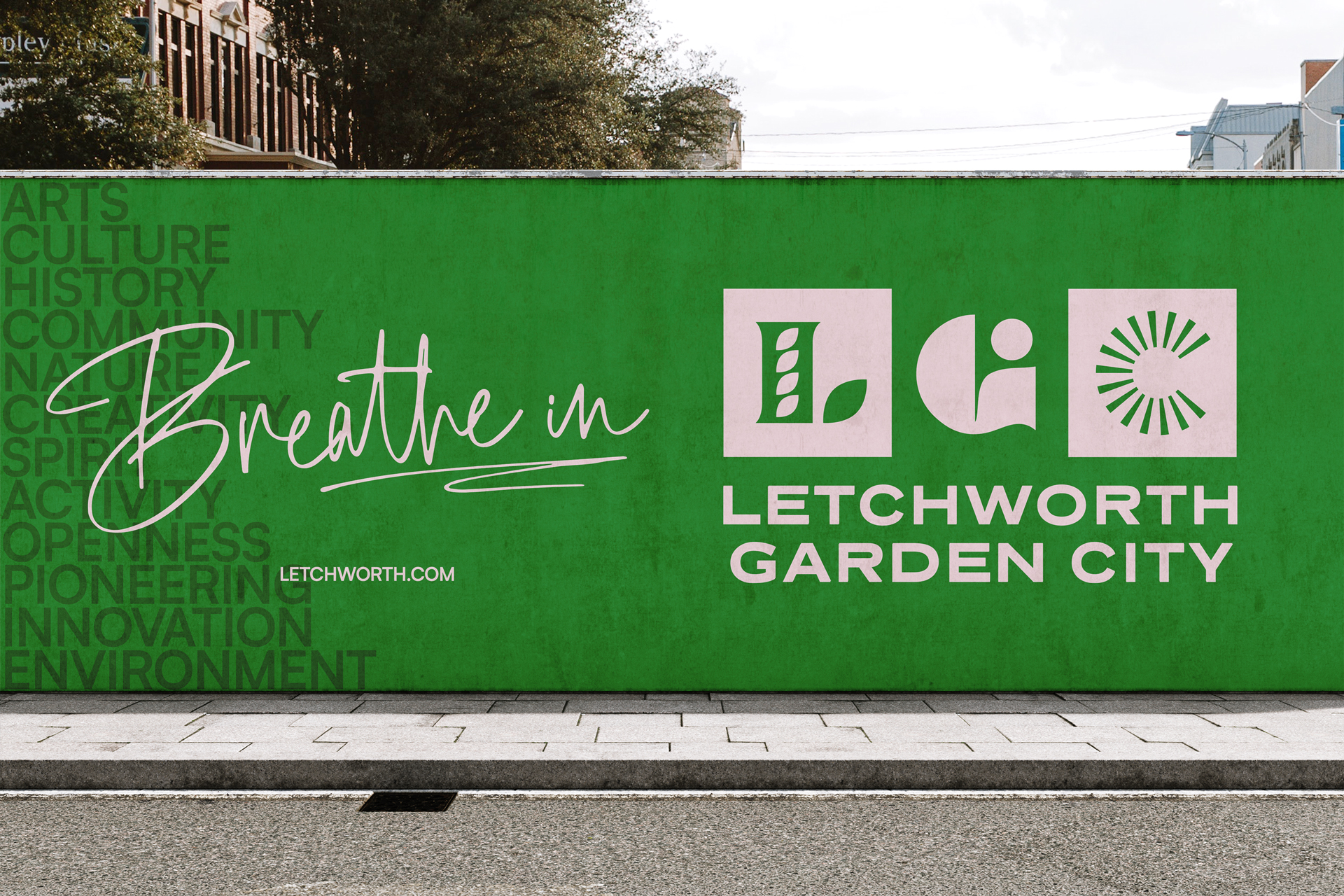 Outdoor branding with “Breathe in” slogan and Letchworth Garden City logo on a green wall.