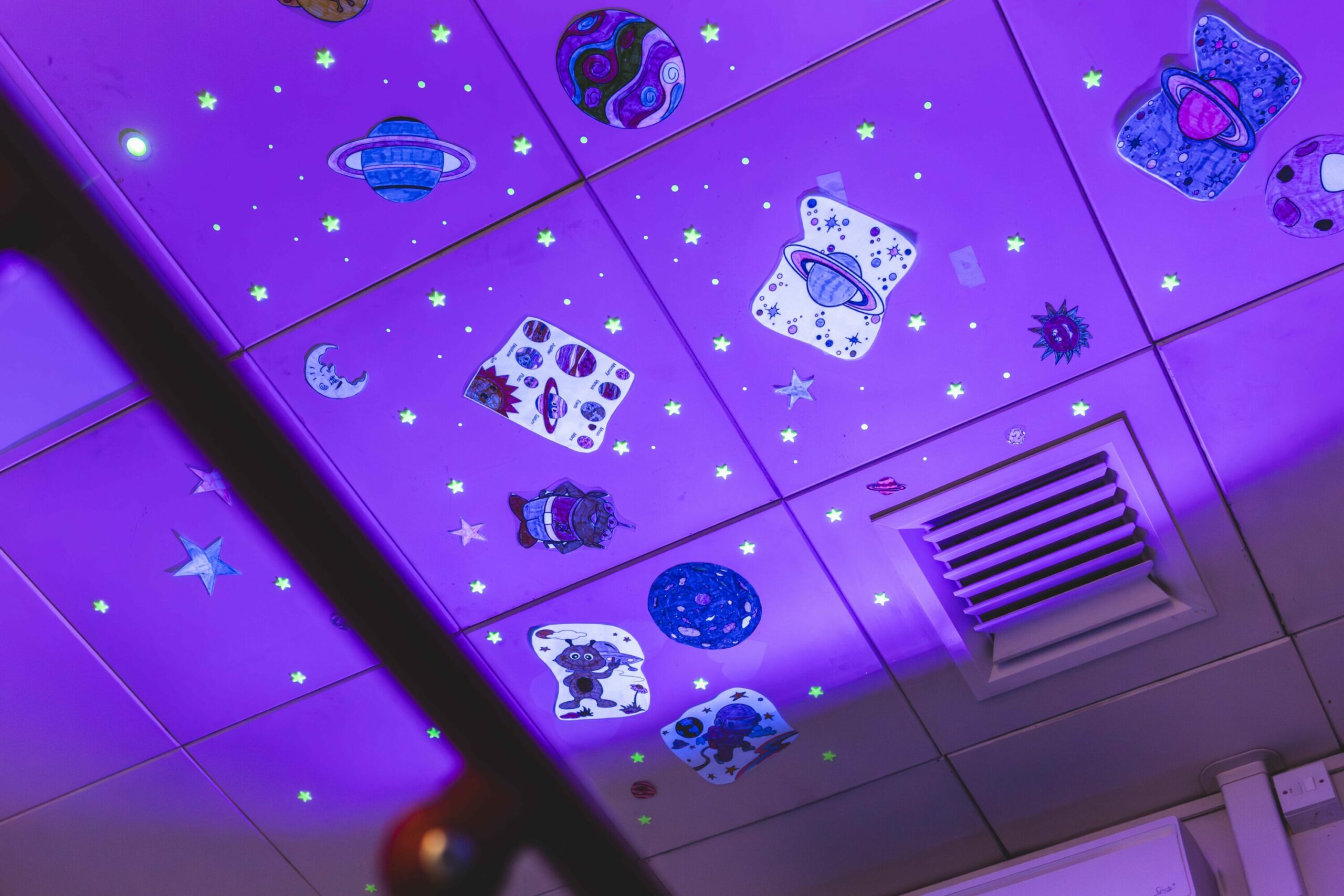 Glow-in-the-dark space-themed ceiling with planets and stars.