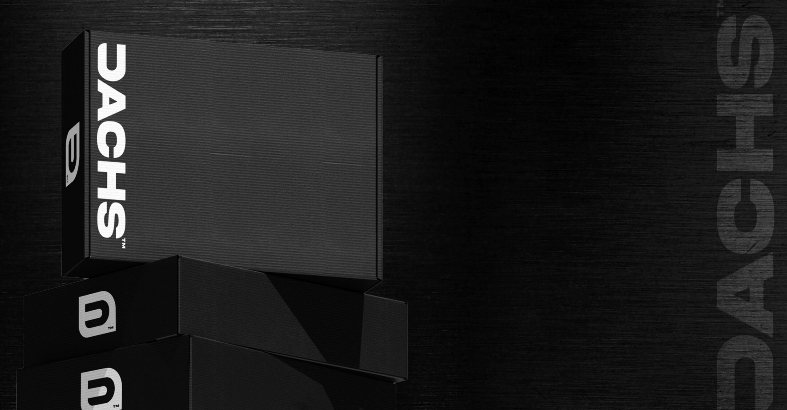 A stack of minimalist black Dachs car care product boxes with the brand's white logo.