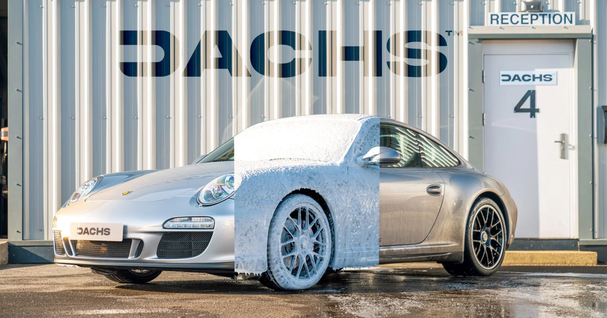 A silver Porsche covered in Dachs cleaning foam, parked in front of the Dachs brand building.