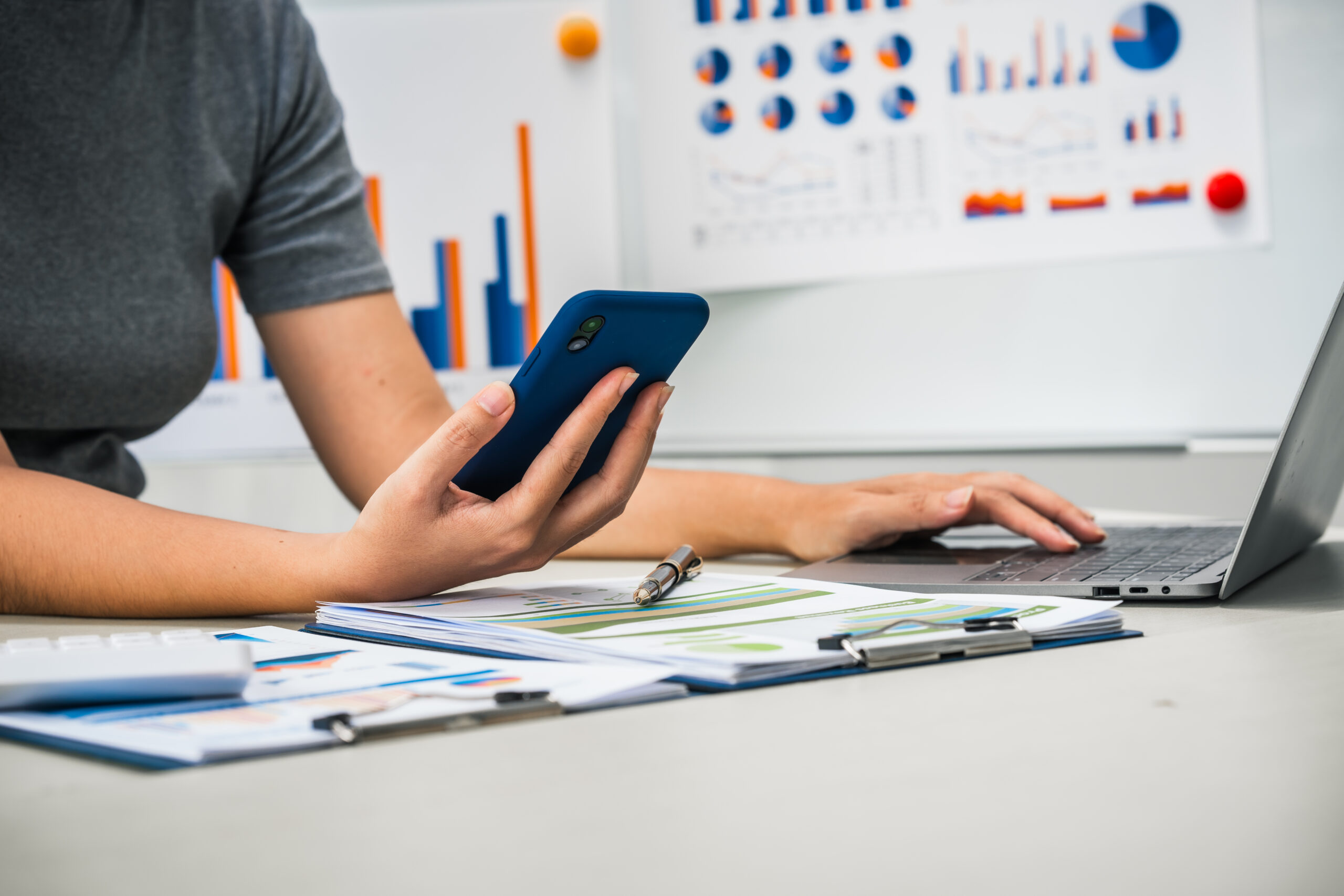woman-works-at-her-desk-holding-a-phone