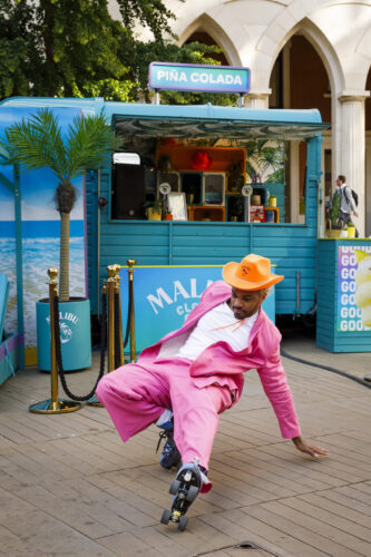 Man in pink suit dancing in roller skates