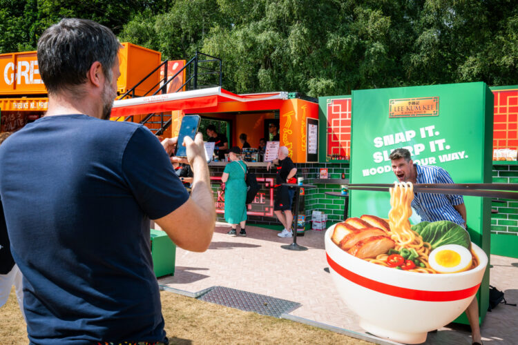Man pretending to eat from large bowl of noodles