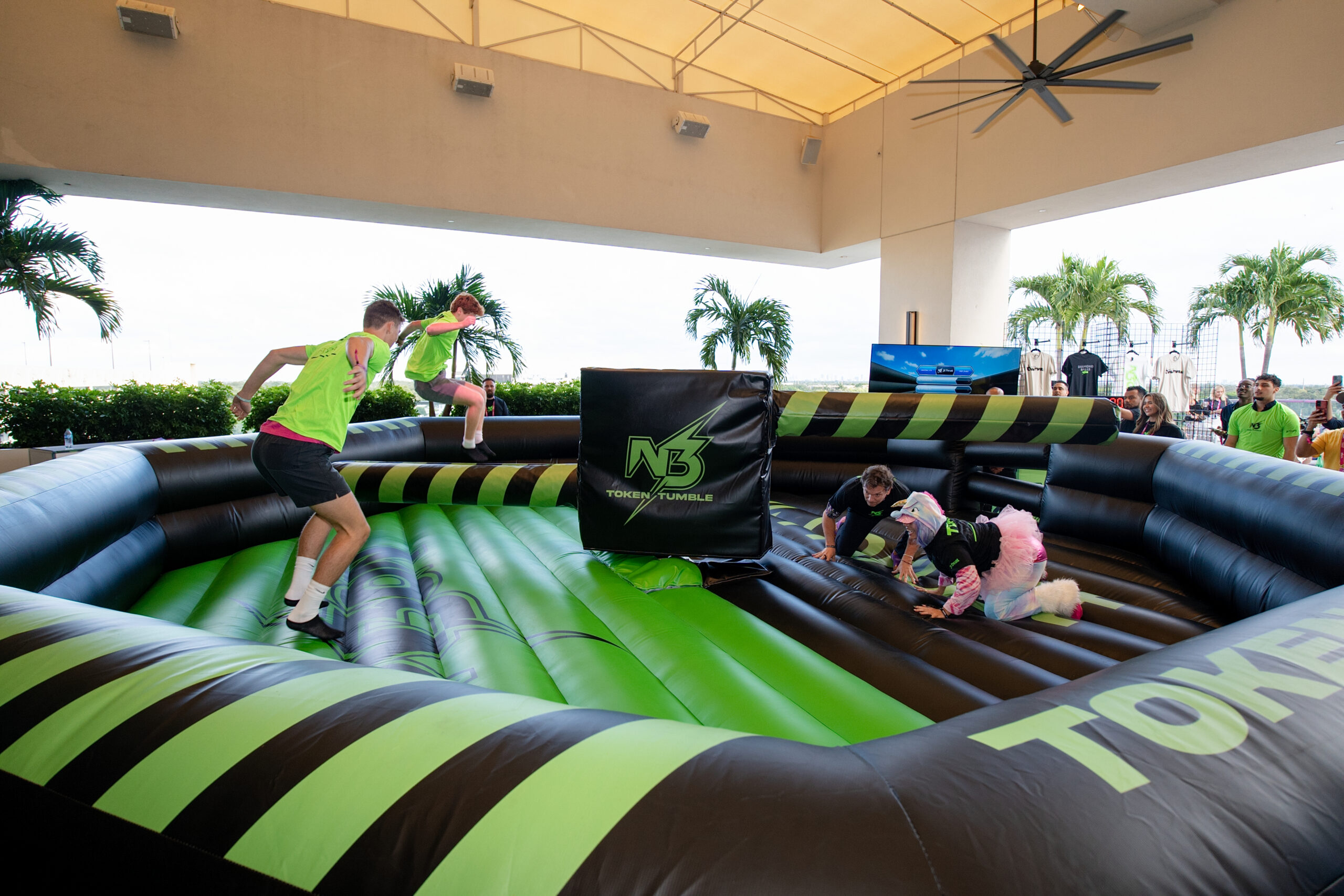 people jumping on a green and black blow up