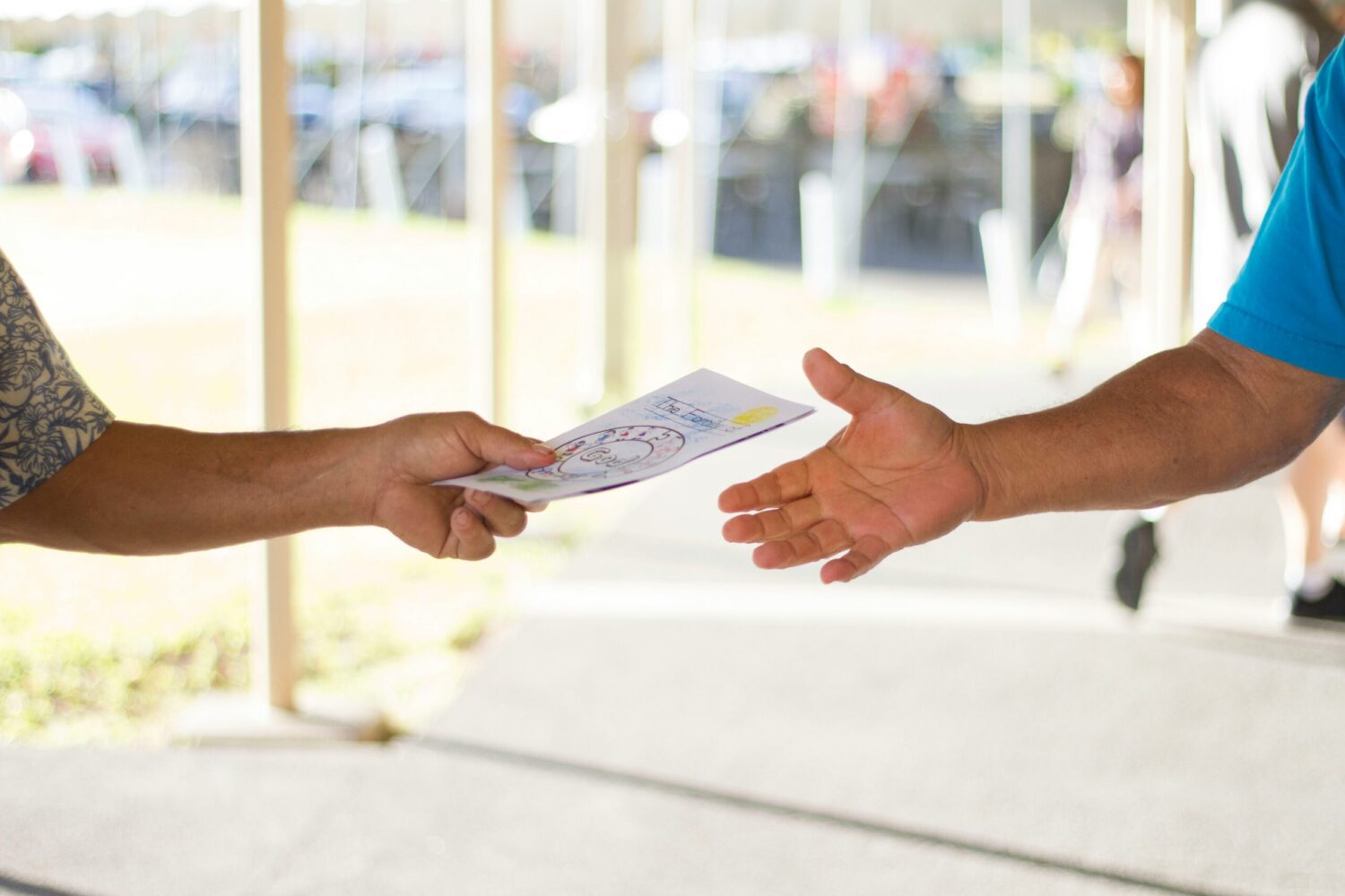 person handing over a leaflet to another person